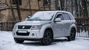 A car in snow, it’s windscreen is covered in frost.