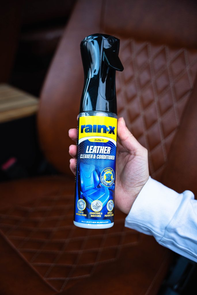 Someone showing a bottle of Rain-X Leather cleaner